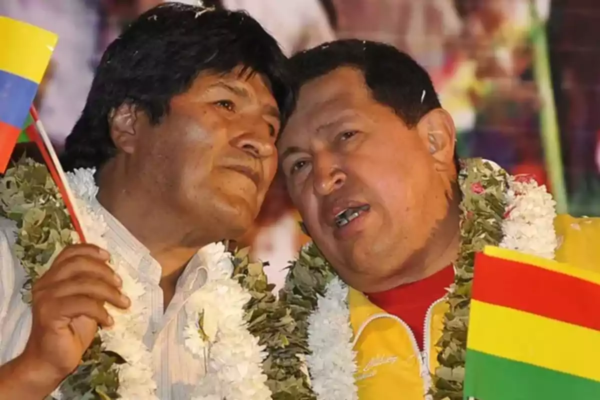 Two people with flower garlands holding flags.