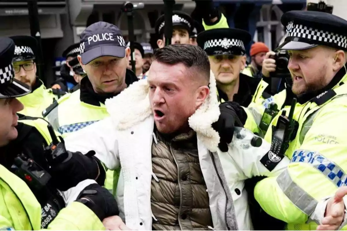 Un grupo de policías detiene a un hombre durante una protesta.