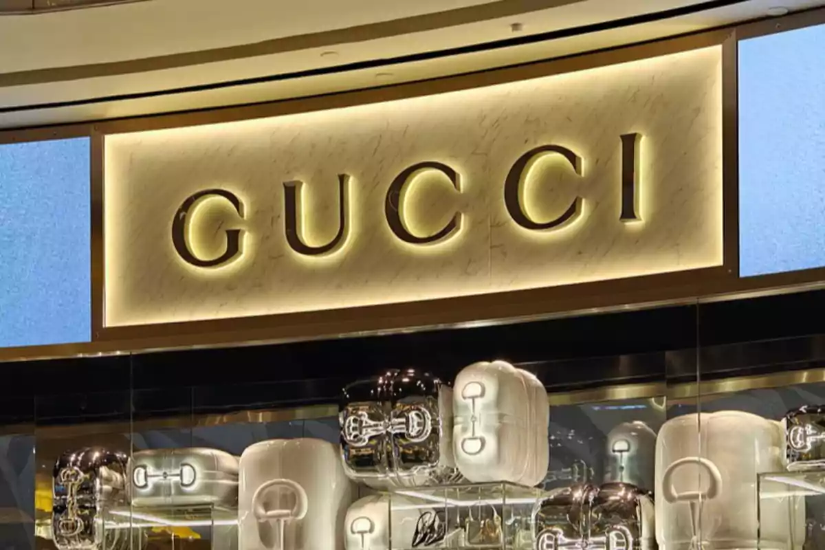 Letrero iluminado de Gucci en una tienda con exhibición de bolsos en el escaparate.