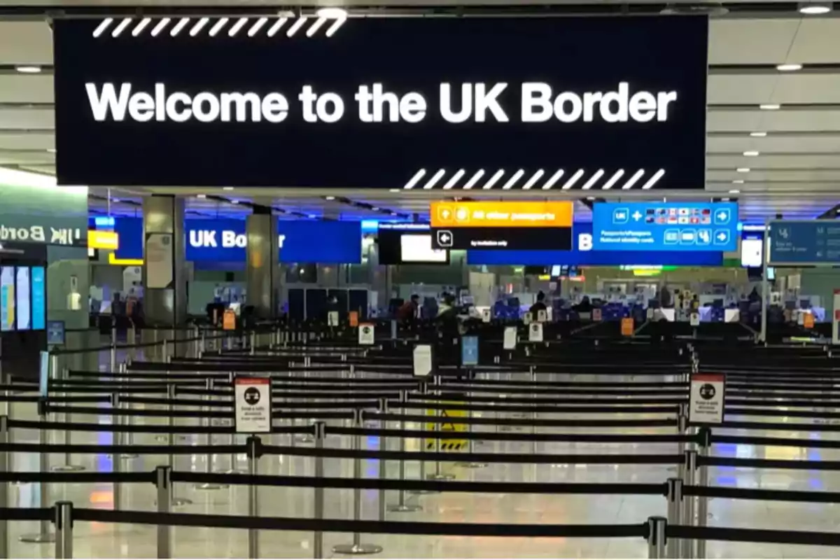 Passport control area at an airport with a sign welcoming to the United Kingdom border. Passport control area at an airport with a sign welcoming to the United Kingdom border.