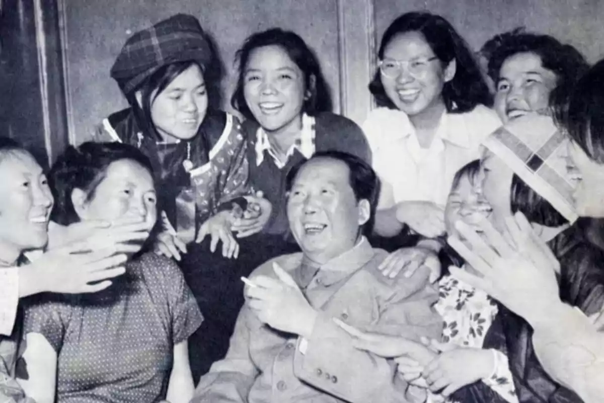 Un grupo de personas sonrientes rodea a un hombre que también está sonriendo.