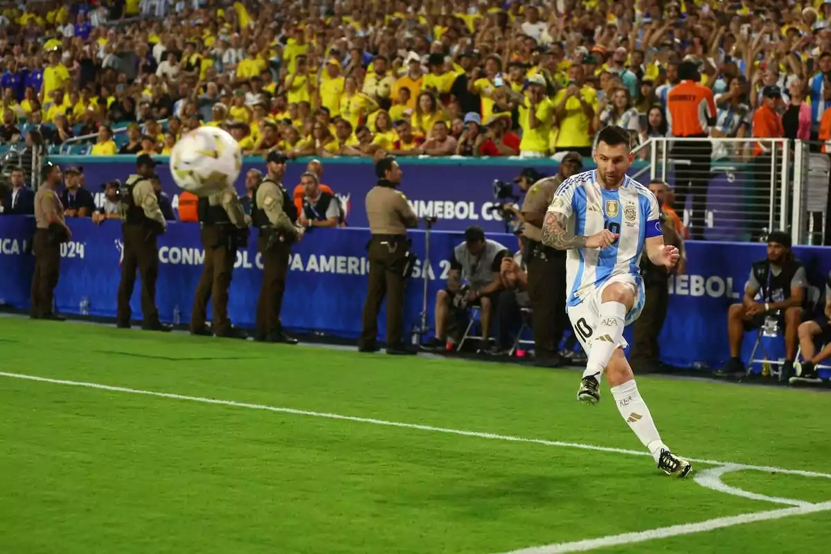 Argentine player taking a corner kick during a match with spectators and security in the background