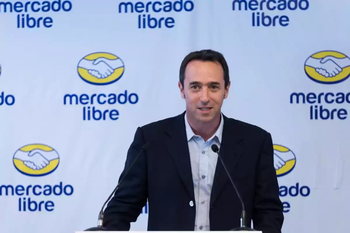 A man speaking at a podium with the Mercado Libre logo in the background.