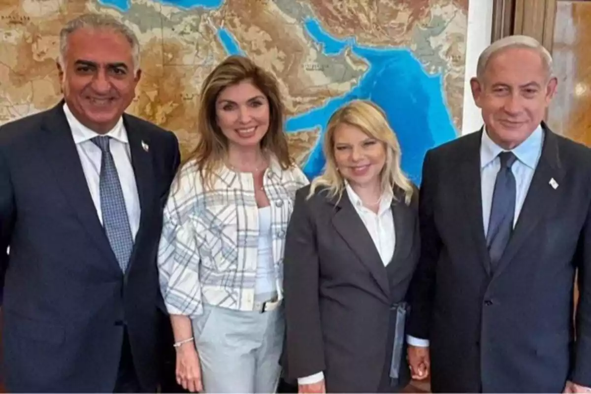 Cuatro personas posan sonrientes frente a un mapa geográfico, dos hombres y dos mujeres vestidos de manera formal. Cuatro personas posan sonrientes frente a un mapa geográfico, dos hombres y dos mujeres vestidos de manera formal.