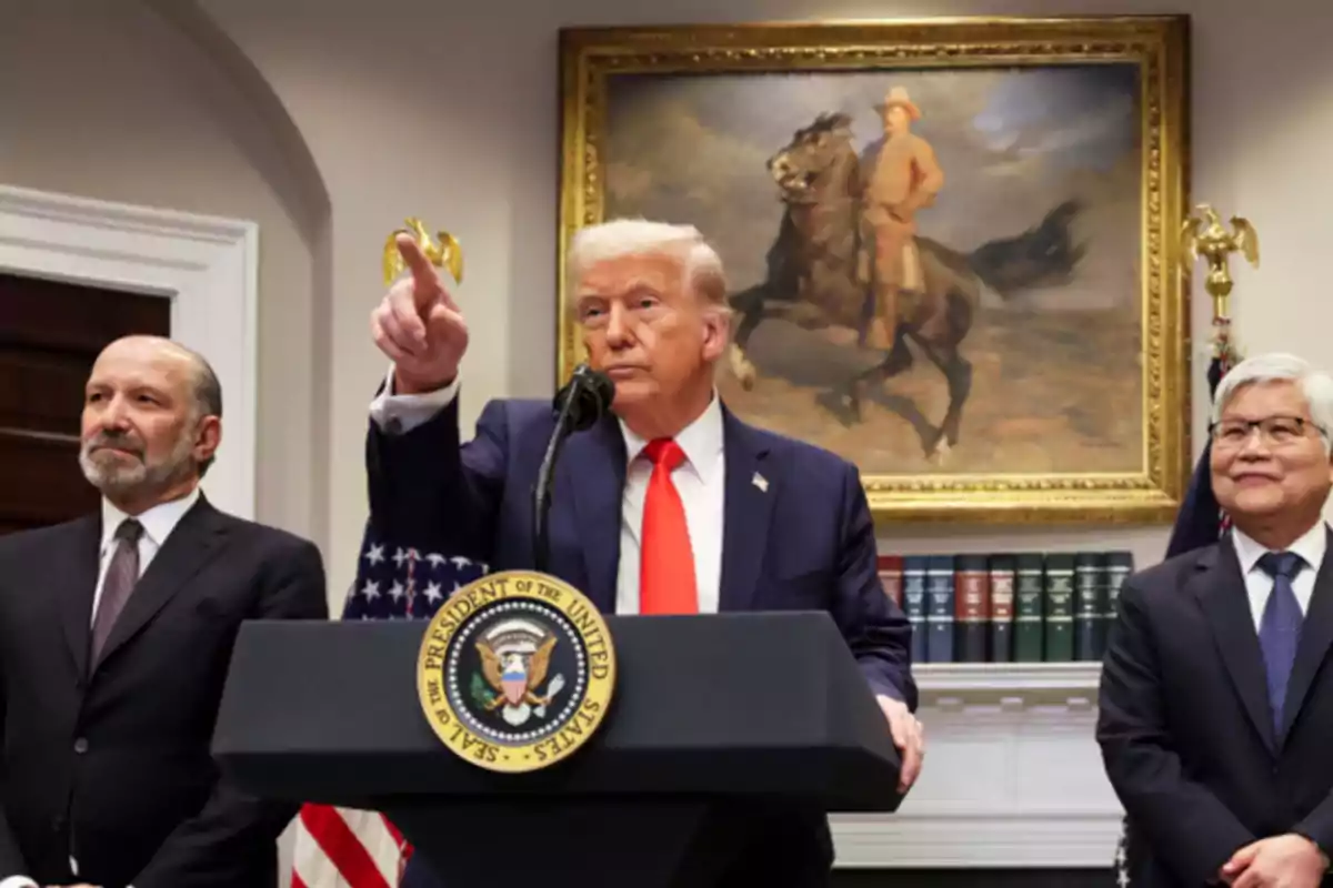 A man at a podium with the presidential seal of the United States, flanked by two people, with a painting of a rider on horseback in the background.