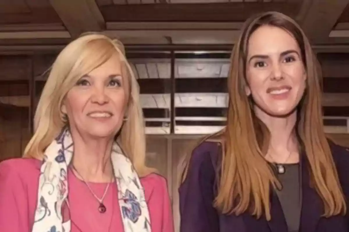 Two women smile as they pose together in an indoor setting with a wooden background.