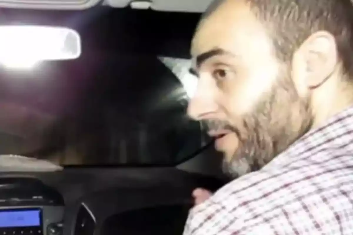 Bearded man in a plaid jersey sitting in the front seat of a car at night, looking back. Bearded man in a plaid jersey sitting in the front seat of a car at night, looking back.