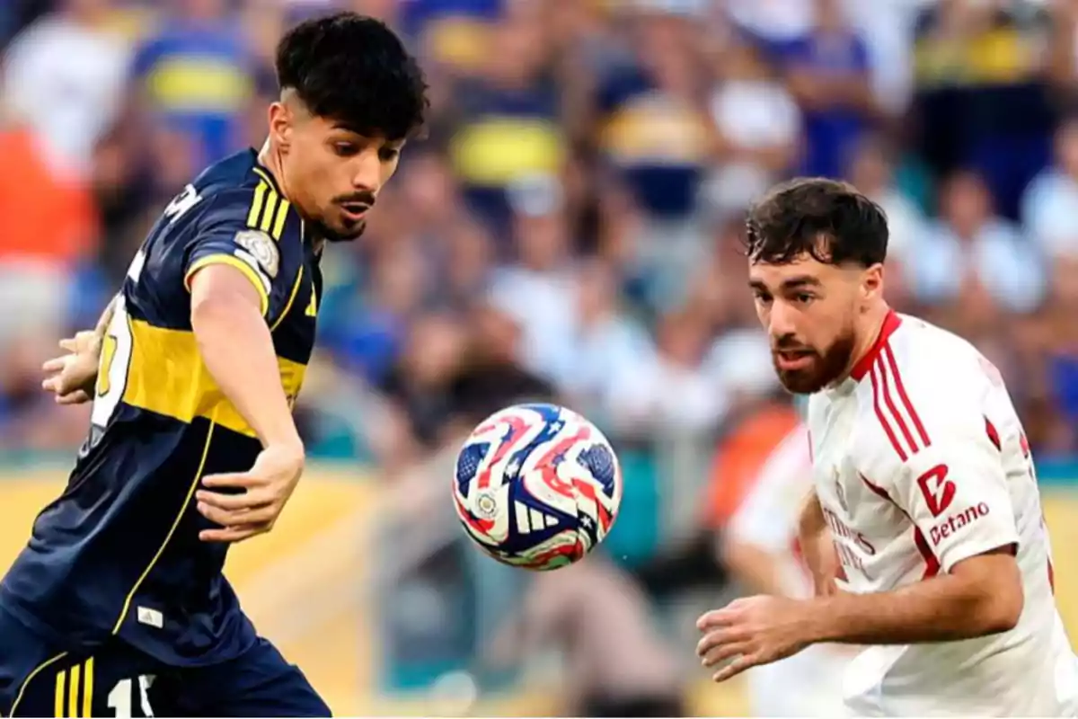 Two players compete for the ball during a match, one wearing a blue and yellow uniform and the other wearing a white and red uniform.