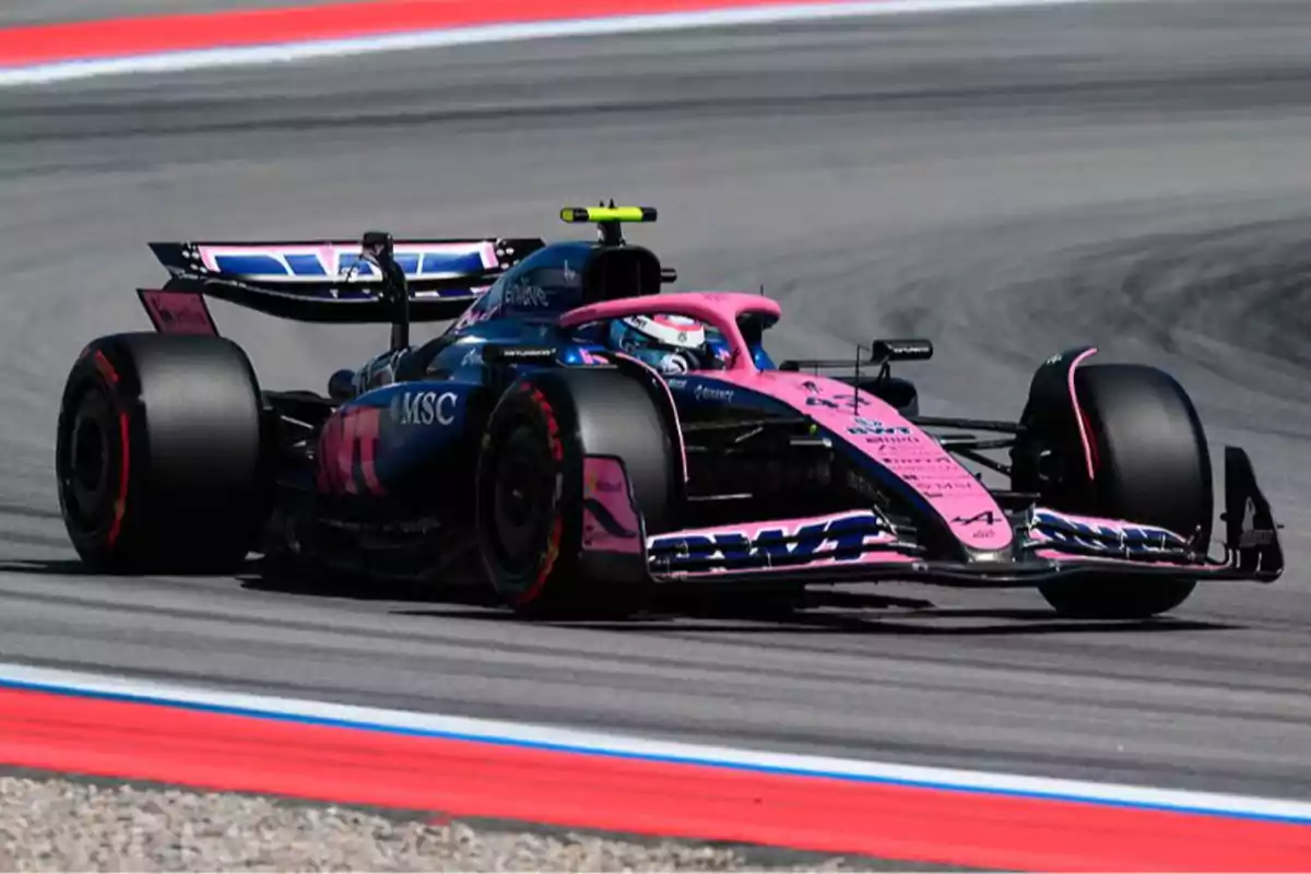 Blue and pink Formula 1 car taking a corner on a racetrack Blue and pink Formula 1 car taking a corner on a racetrack