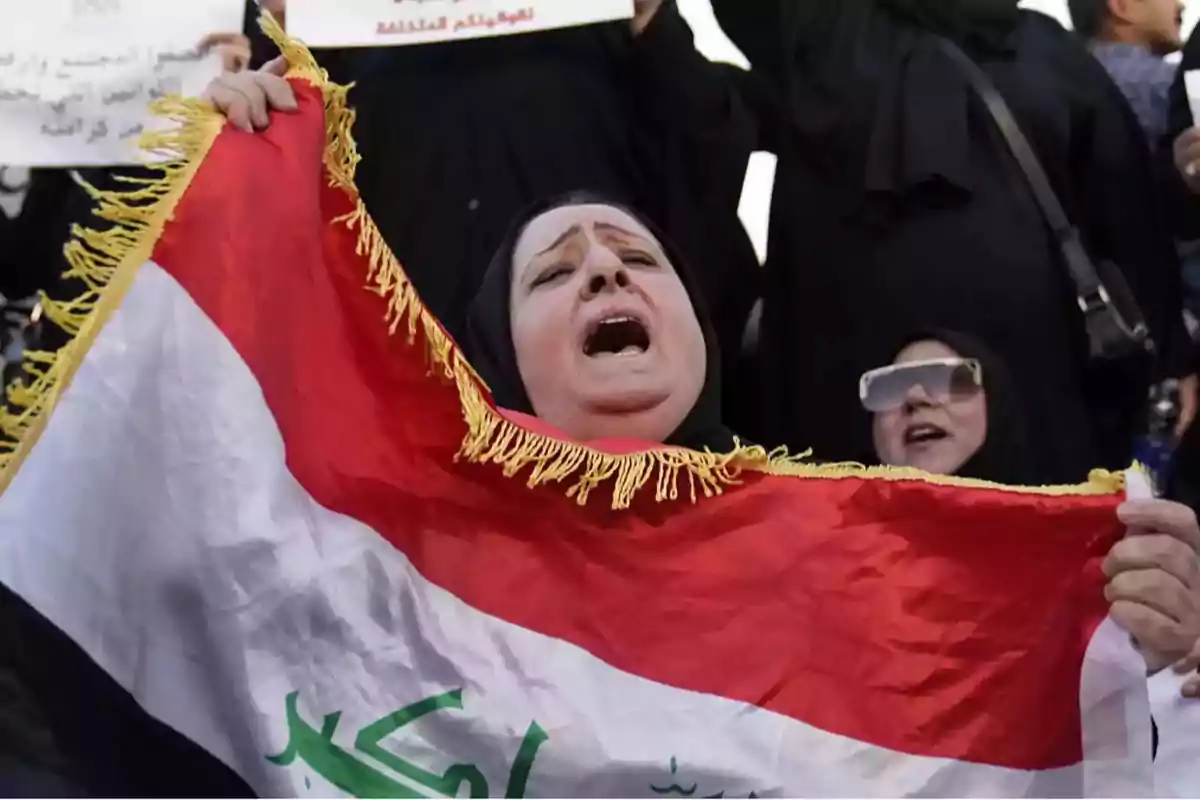 Mujer sosteniendo una bandera con expresión de emoción en una manifestación.