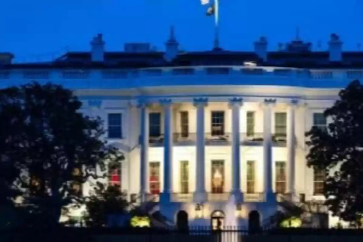White building with columns lit up at night.