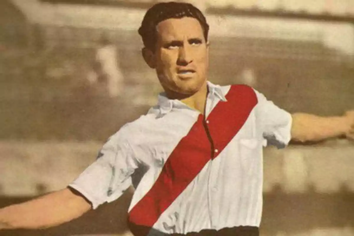 Un futbolista con camiseta blanca y banda roja en acción en un campo de juego.