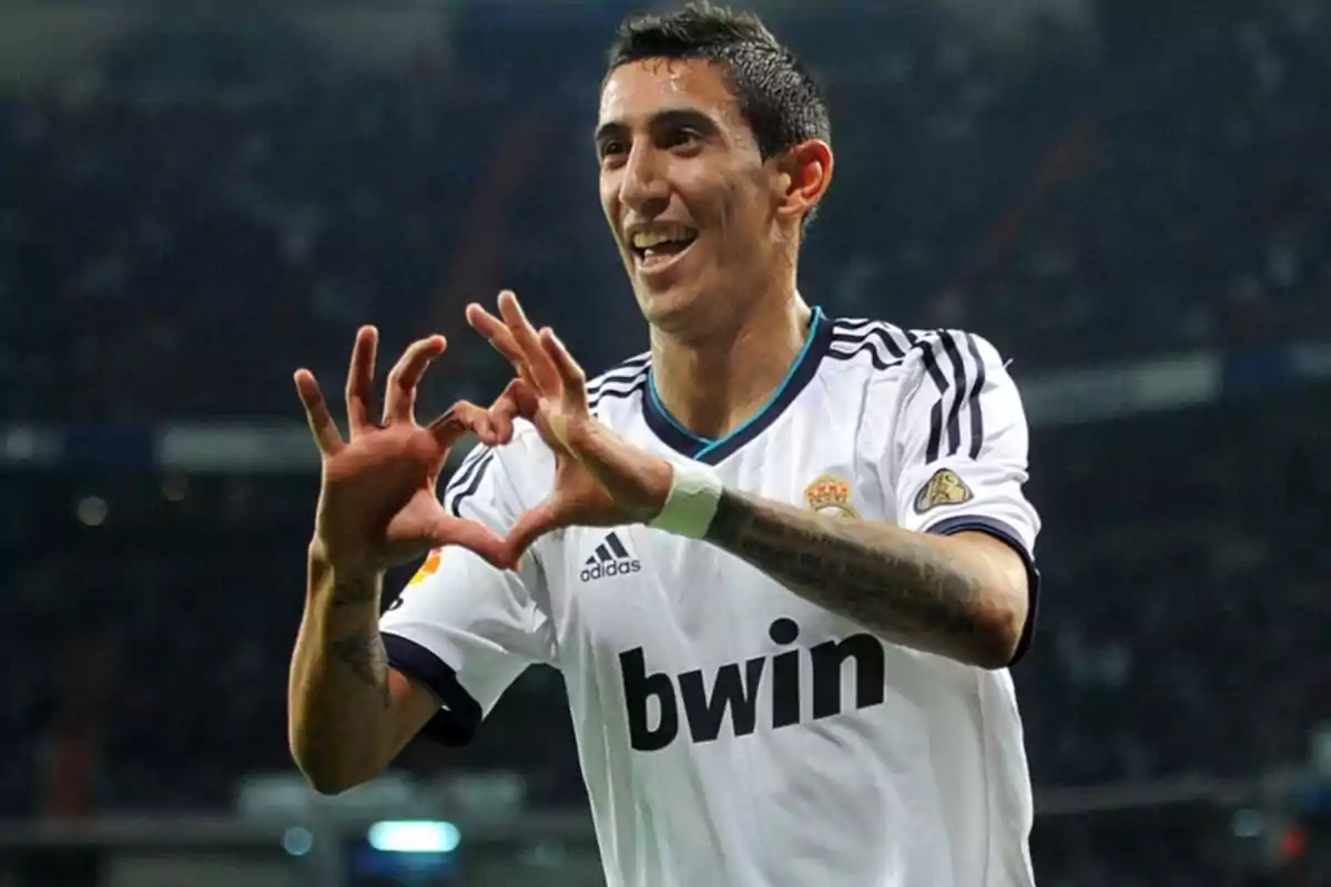 A player in a white uniform makes a heart gesture with his hands in a stadium. A player in a white uniform makes a heart gesture with his hands in a stadium.