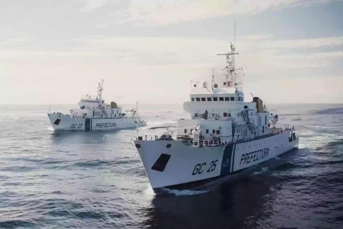 Dos barcos de la Prefectura Naval Argentina navegan en el mar bajo un cielo parcialmente nublado