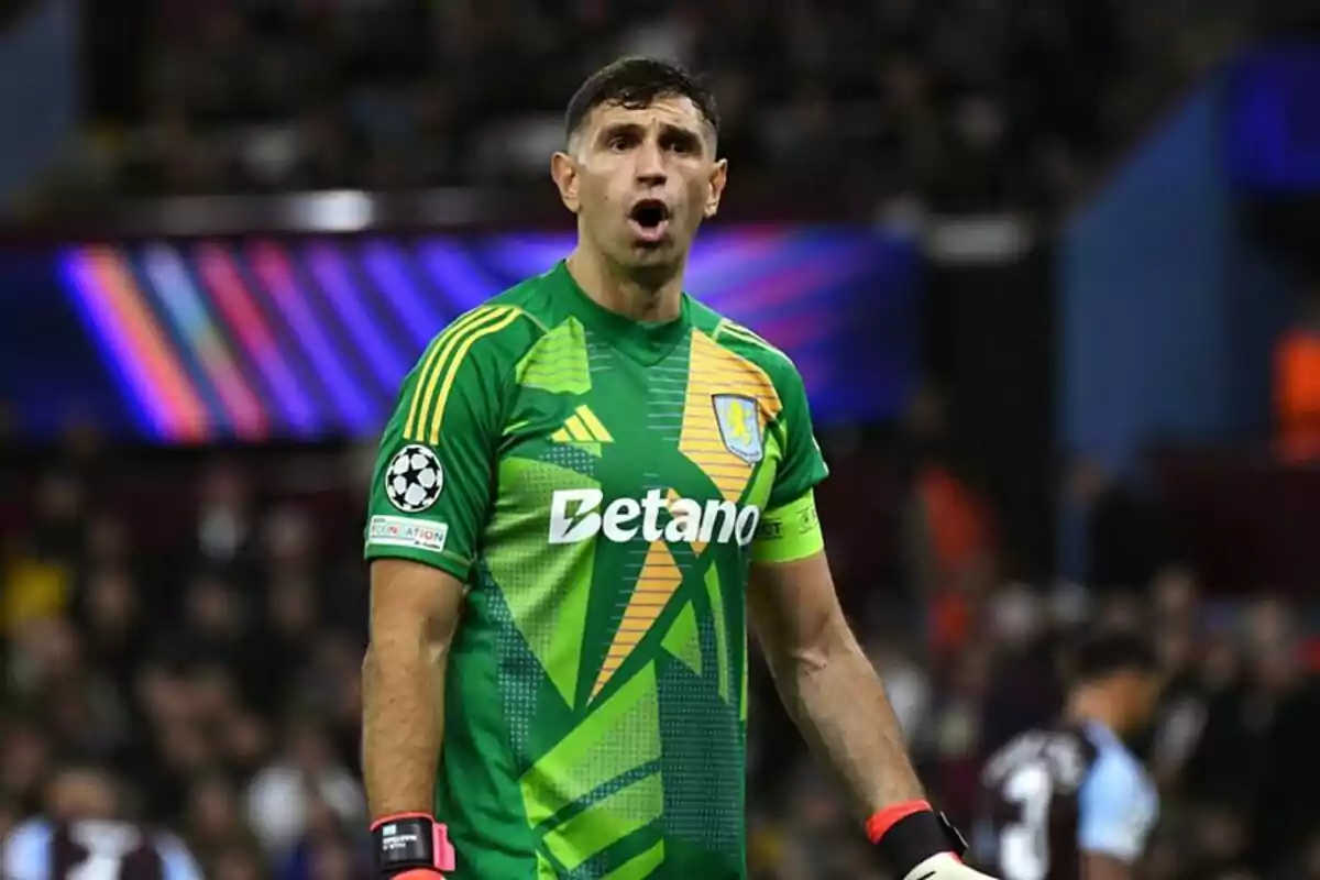 Portero de fútbol con uniforme verde y amarillo en un estadio durante un partido mostrando una expresión de sorpresa o emoción Portero de fútbol con uniforme verde y amarillo en un estadio durante un partido mostrando una expresión de sorpresa o emoción