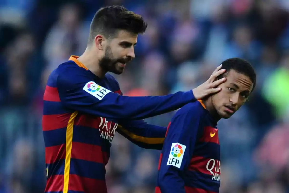 Dos futbolistas del Barcelona con uniforme azulgrana, uno de ellos toca la cabeza del otro en un gesto amistoso durante un partido Dos futbolistas del Barcelona con uniforme azulgrana, uno de ellos toca la cabeza del otro en un gesto amistoso durante un partido