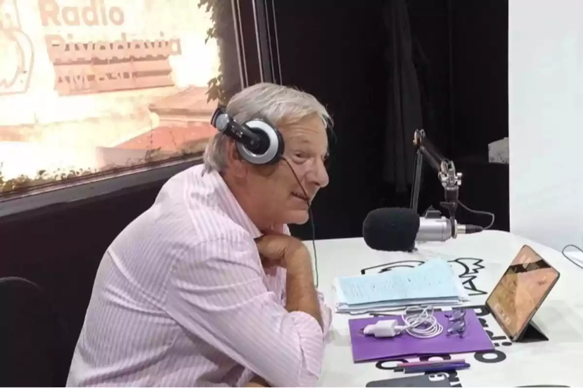 Un hombre con auriculares está hablando frente a un micrófono en un estudio de radio.