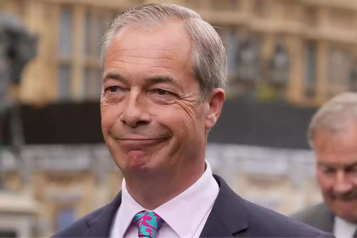 A gray-haired man in a dark suit smiles slightly while standing outdoors. A gray-haired man in a dark suit smiles slightly while standing outdoors.