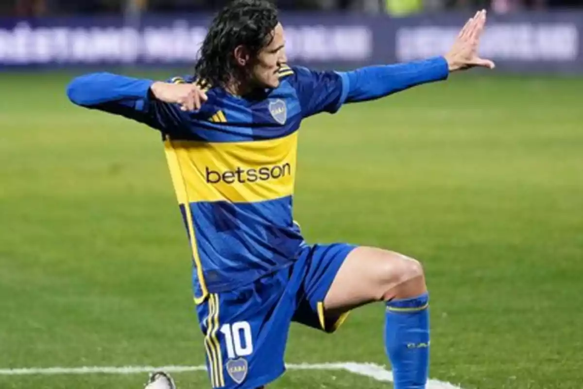 Jugador de fútbol celebrando un gol en el campo con uniforme azul y amarillo.