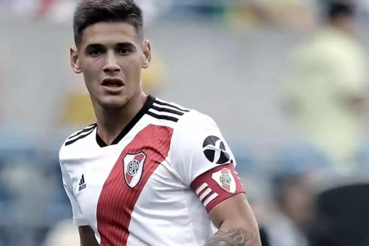 Jugador de fútbol con camiseta de River Plate en el campo de juego.