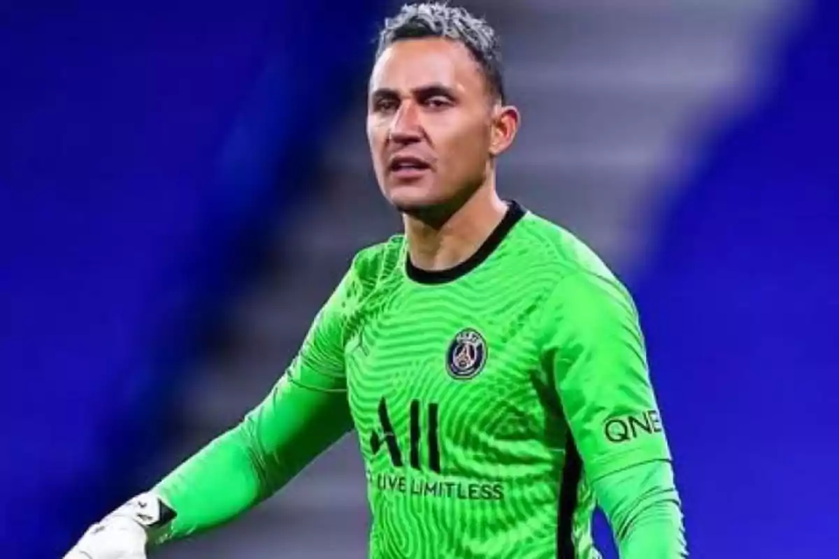 Un jugador de fútbol con uniforme verde en el campo.