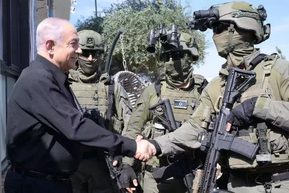 Un hombre de camisa negra estrechando la mano con un soldado en uniforme militar mientras otros soldados observan.