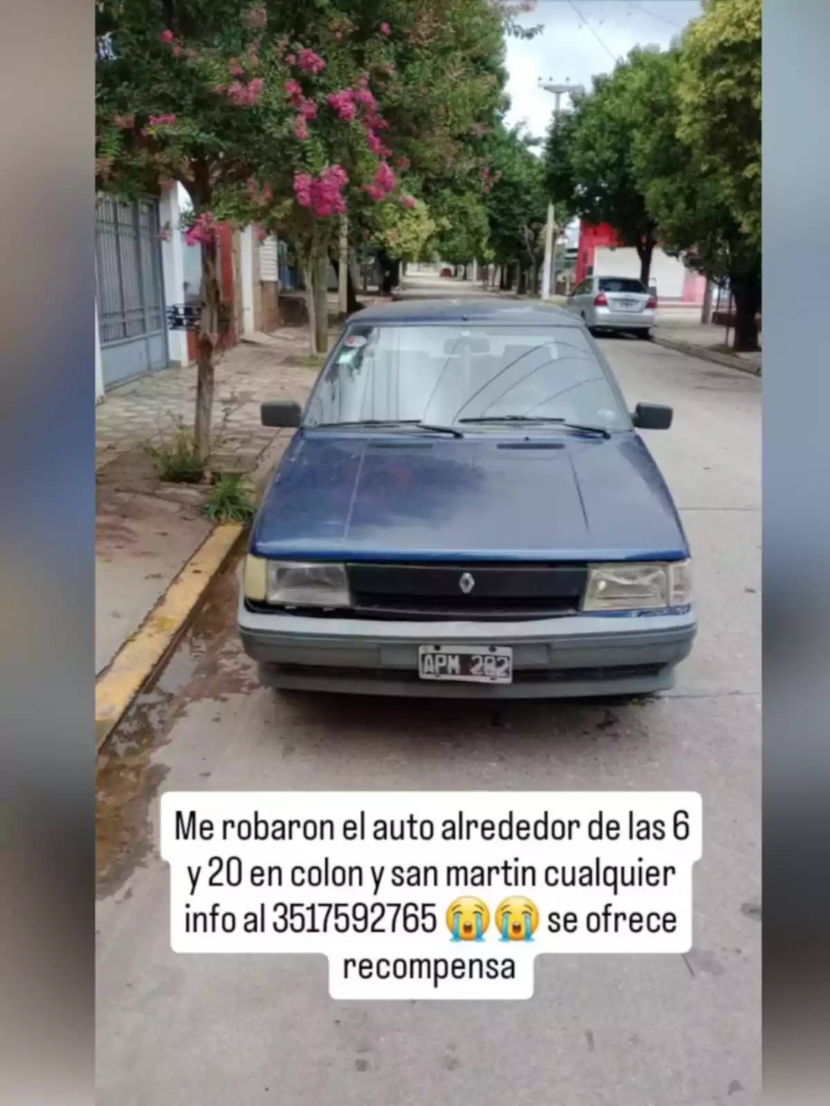 Auto Renault azul estacionado en la calle con un mensaje sobre robo y un número de contacto para información y recompensa Auto Renault azul estacionado en la calle con un mensaje sobre robo y un número de contacto para información y recompensa