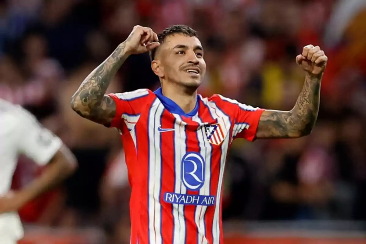 Atlético de Madrid player celebrating a goal with arms raised during a match Atlético de Madrid player celebrating a goal with arms raised during a match