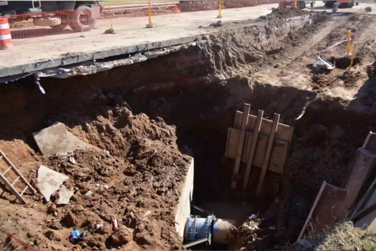 Deep excavation on a street with machinery and exposed piping Deep excavation on a street with machinery and exposed piping
