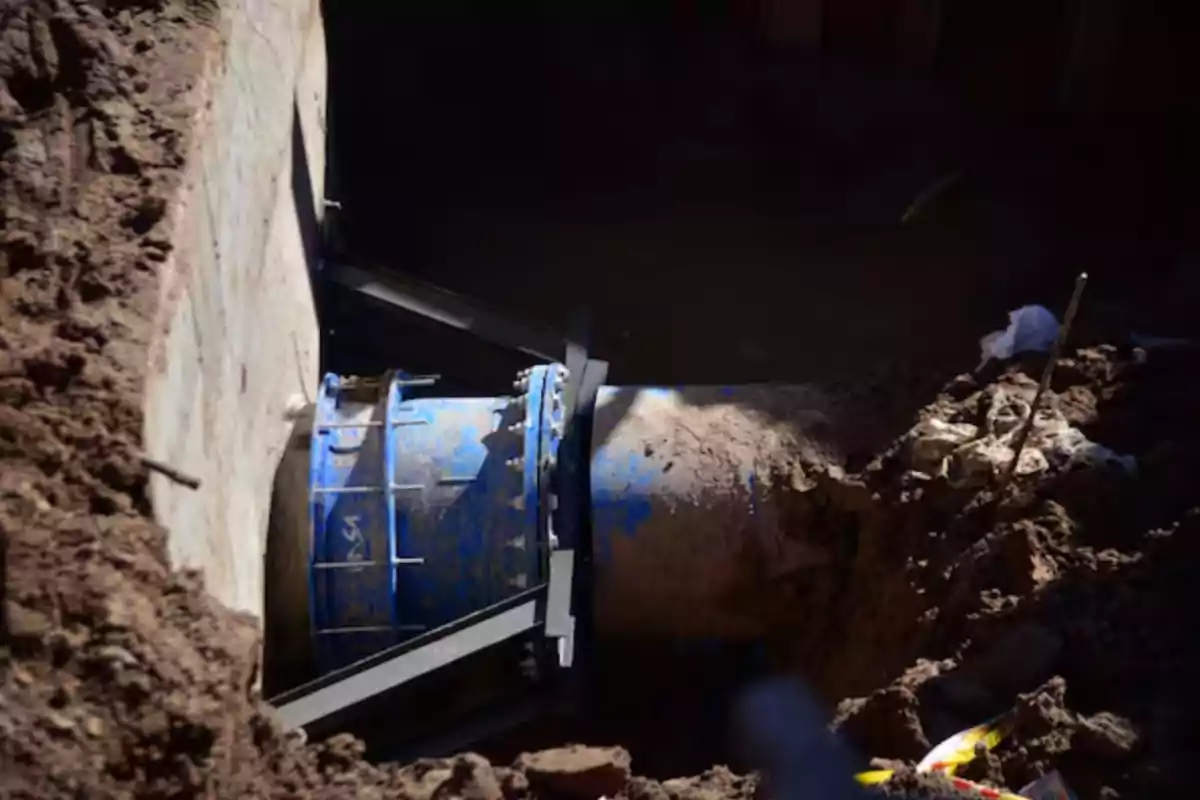 Large blue pipe partially buried in an earthen trench Large blue pipe partially buried in an earthen trench