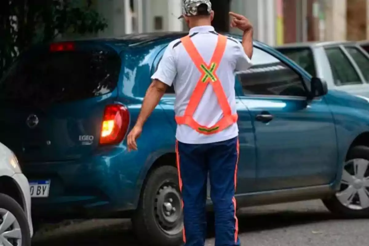 A man wearing a reflective vest is directing the parking of a blue car on the street. A man wearing a reflective vest is directing the parking of a blue car on the street.