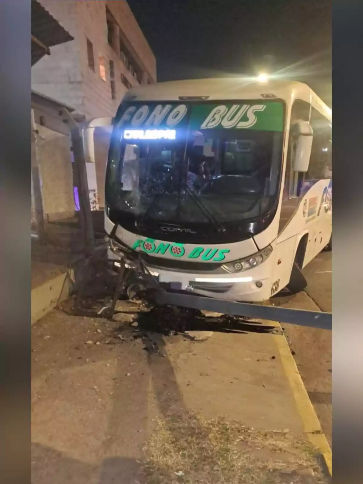 A Fono Bus company bus crashed into a metal structure on the sidewalk during the night. A Fono Bus company bus crashed into a metal structure on the sidewalk during the night.