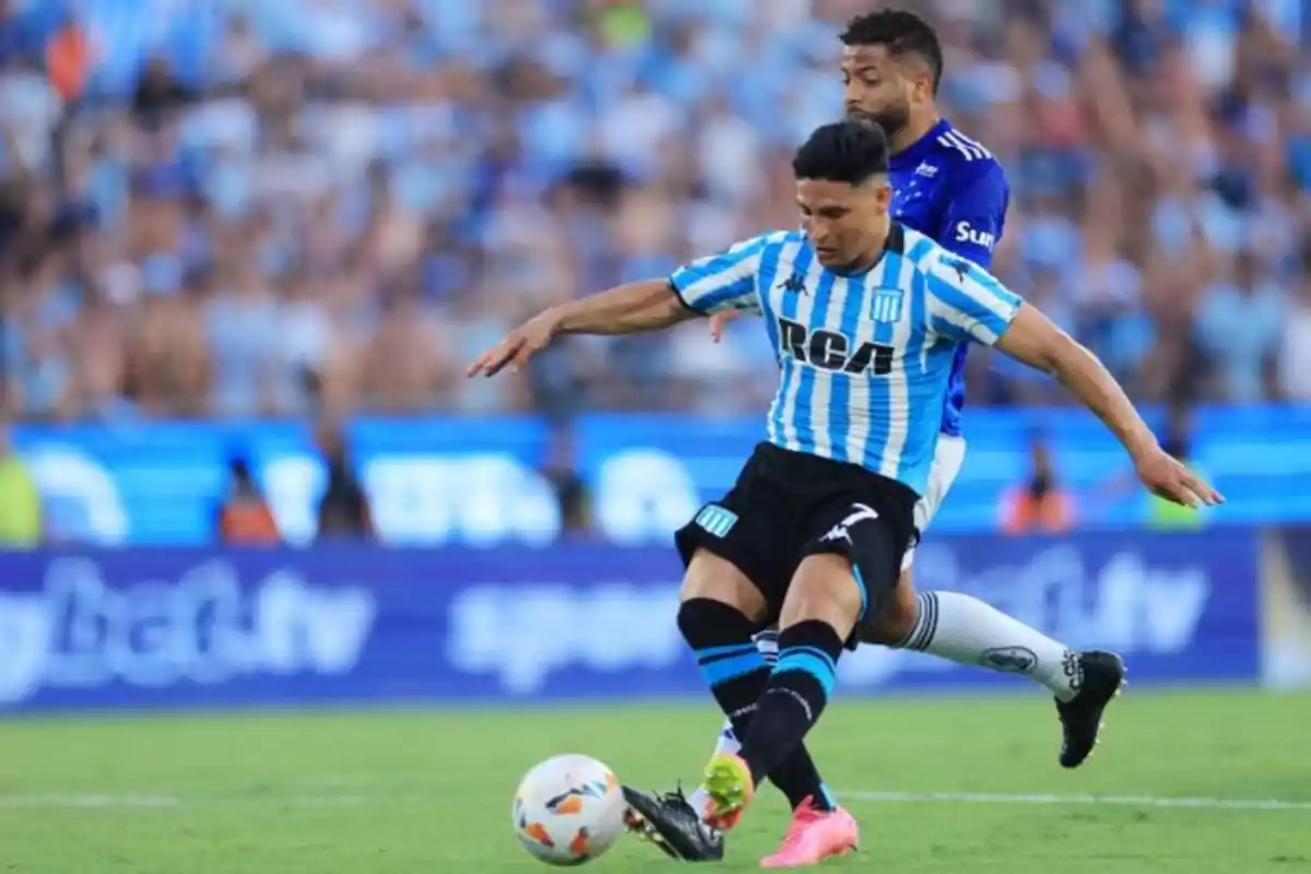 Two players compete for the ball during a match in a packed stadium. Two players compete for the ball during a match in a packed stadium.