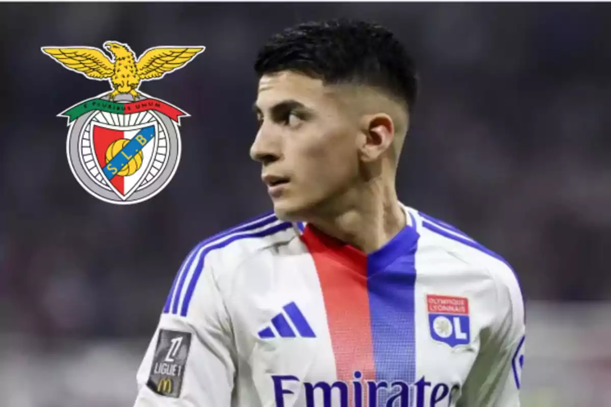Futbolista con uniforme del Olympique de Lyon mirando hacia la izquierda con el escudo del Benfica al fondo