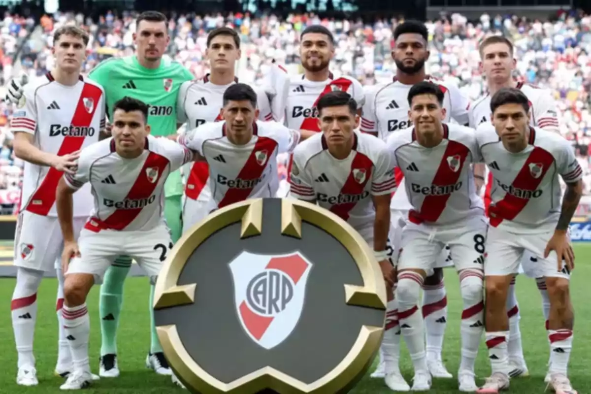 Once jugadores de fútbol del equipo River Plate posan juntos en la cancha antes de un partido con el escudo del club al frente