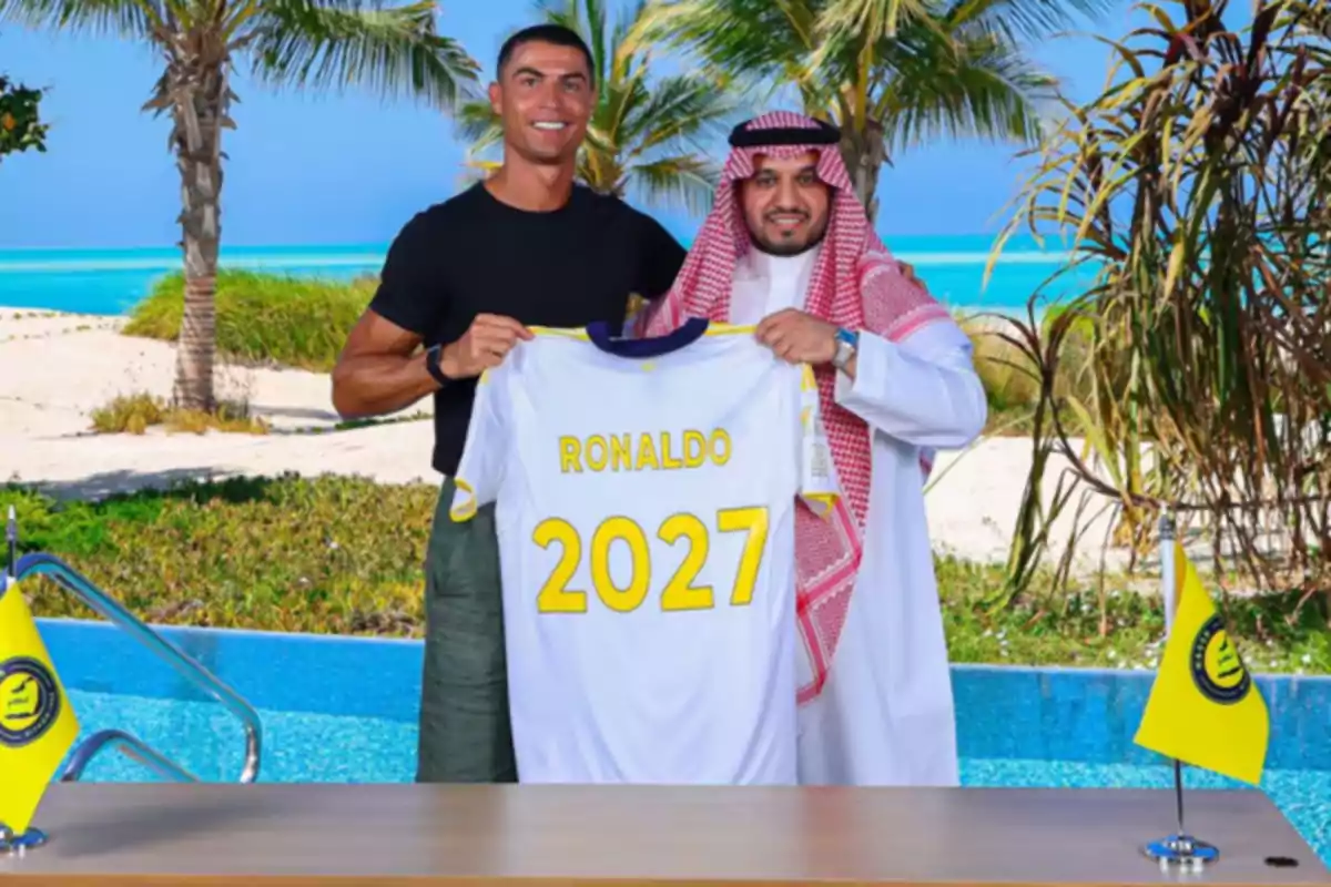 Two people smile while holding a white soccer jersey with the name Ronaldo and the number 2027 in a tropical setting next to a pool and palm trees.