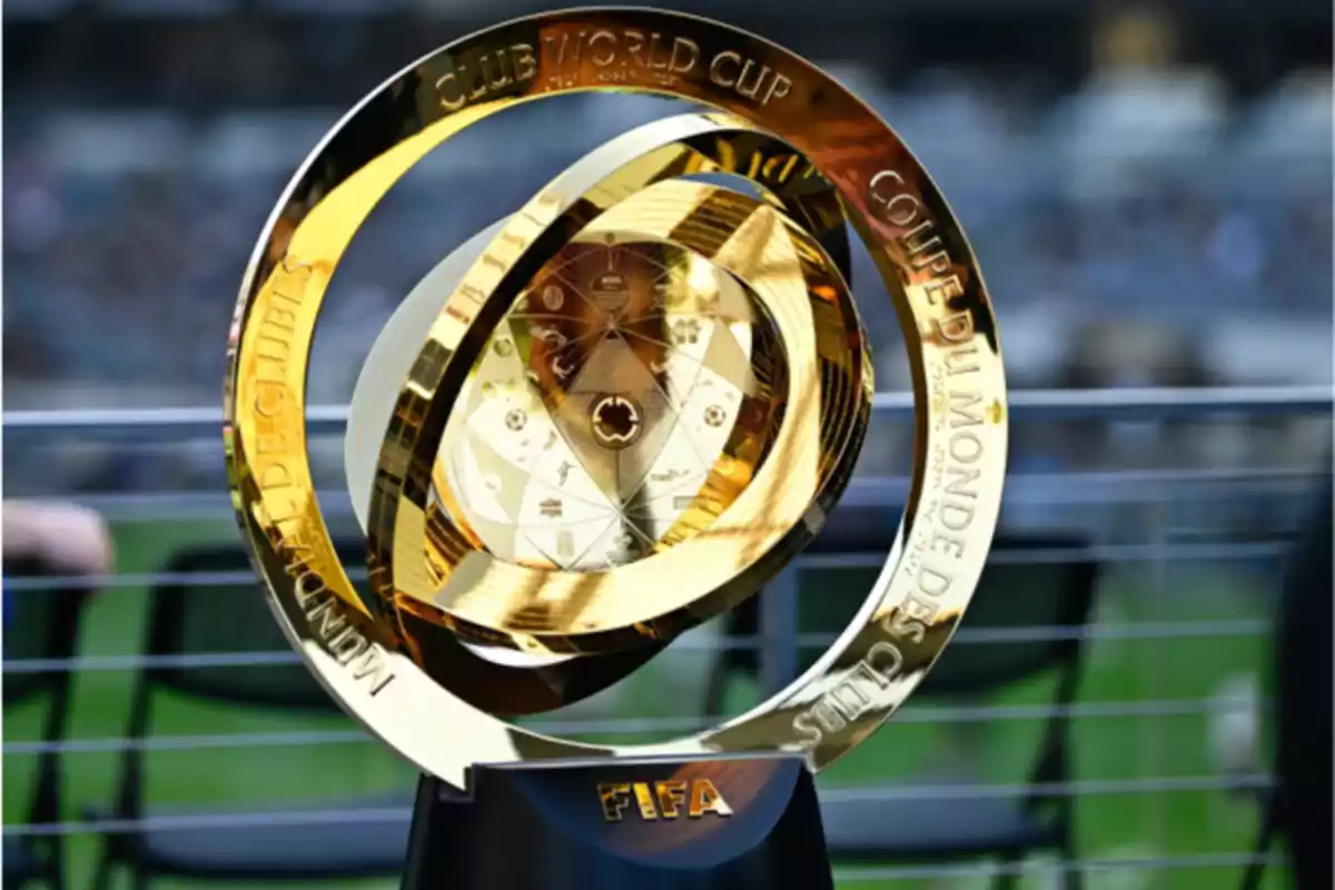 FIFA Club World Cup golden trophy on a black base with a blurred stadium background