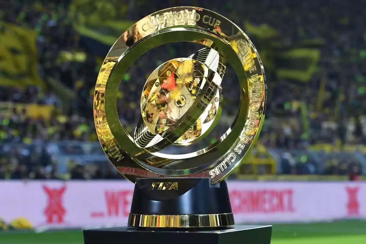 FIFA Club World Cup golden trophy on a black base in a stadium full of fans