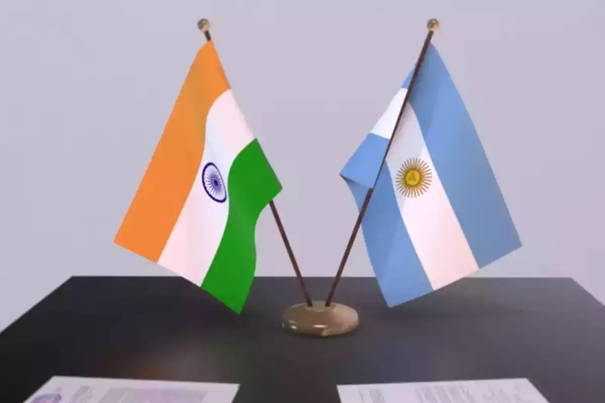 Two small flags of India and Argentina crossed on a black table with documents. Two small flags of India and Argentina crossed on a black table with documents.