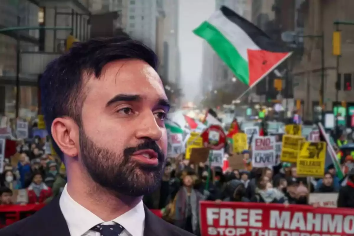 A bearded man in a suit appears in the foreground while in the background a protest with signs and a large Palestinian flag waving among the crowd can be seen.