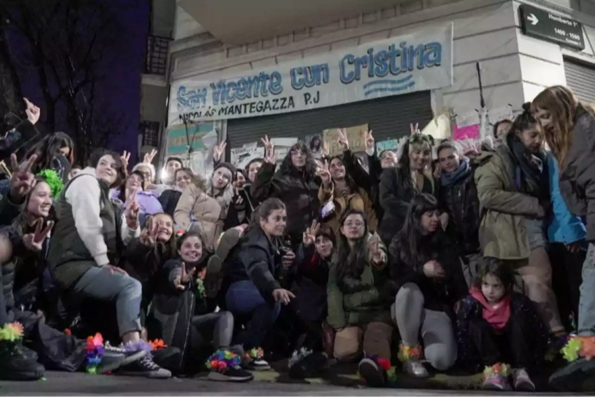 Grupo de personas reunidas en la calle frente a un cartel que dice San Vicente con Cristina, muchas de ellas haciendo el gesto de la V de la victoria con las manos y usando ropa abrigada Grupo de personas reunidas en la calle frente a un cartel que dice San Vicente con Cristina, muchas de ellas haciendo el gesto de la V de la victoria con las manos y usando ropa abrigada