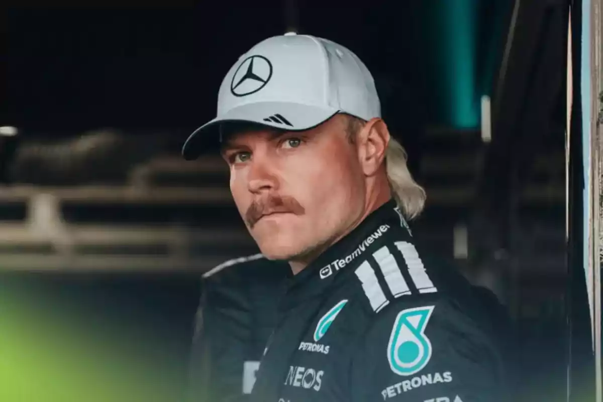 Piloto de automovilismo con uniforme de Mercedes y gorra blanca mirando hacia la cámara Piloto de automovilismo con uniforme de Mercedes y gorra blanca mirando hacia la cámara