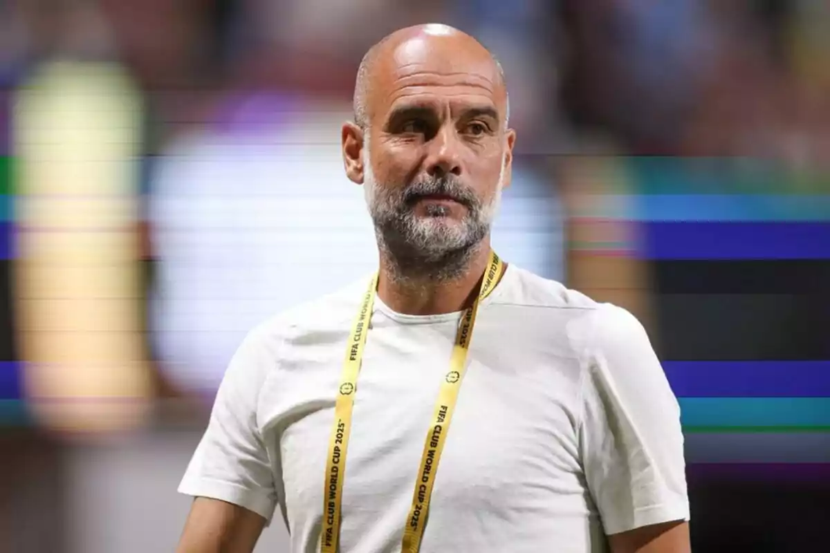Hombre calvo con barba y camiseta blanca usando un gafete amarillo en un estadio Hombre calvo con barba y camiseta blanca usando un gafete amarillo en un estadio