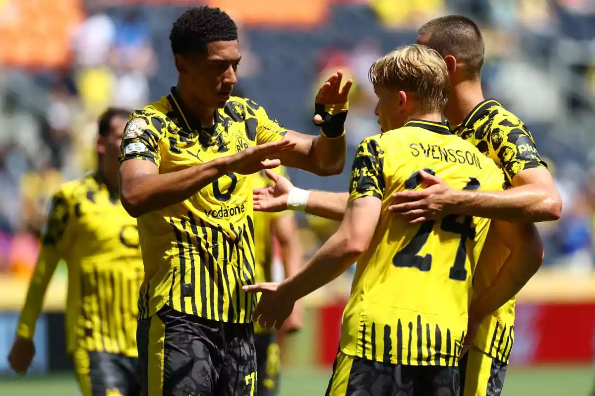 Soccer players in yellow and black uniforms celebrate during a match on the field. Soccer players in yellow and black uniforms celebrate during a match on the field.