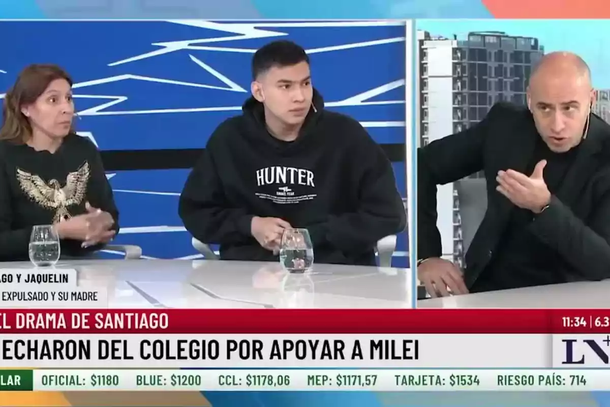 Tres personas participan en un programa de televisión discutiendo un tema controversial con un gráfico de precios en la parte inferior de la pantalla y un fondo azul con líneas blancas Tres personas participan en un programa de televisión discutiendo un tema controversial con un gráfico de precios en la parte inferior de la pantalla y un fondo azul con líneas blancas