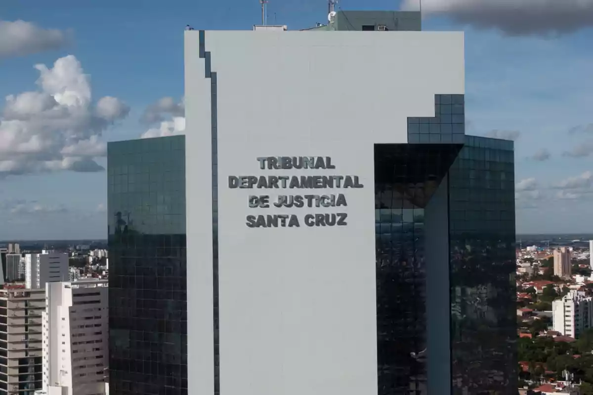 Modern building of the Departmental Court of Justice of Santa Cruz with blue sky and city in the background Modern building of the Departmental Court of Justice of Santa Cruz with blue sky and city in the background