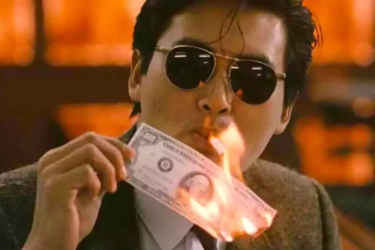 Man with sunglasses lighting a burning bill to use it as a cigar Man with sunglasses lighting a burning bill to use it as a cigar