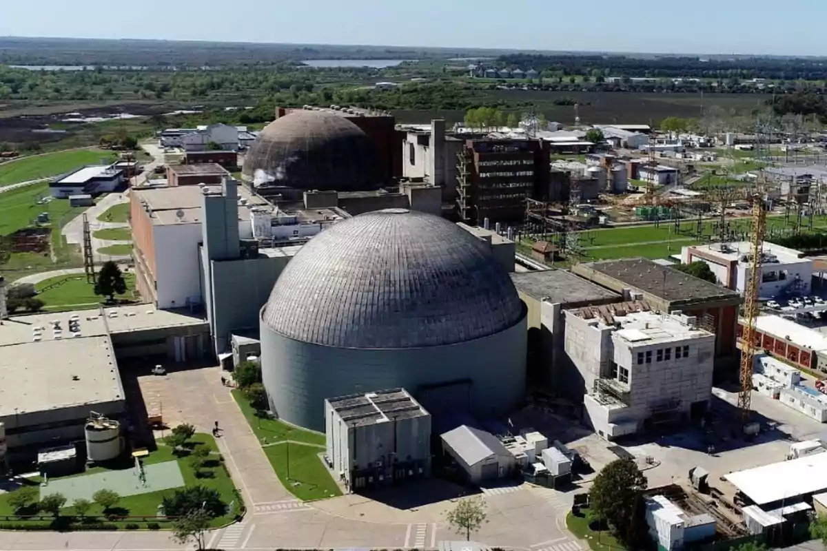 Vista aérea de una planta nuclear rodeada de áreas verdes y edificios industriales Vista aérea de una planta nuclear rodeada de áreas verdes y edificios industriales