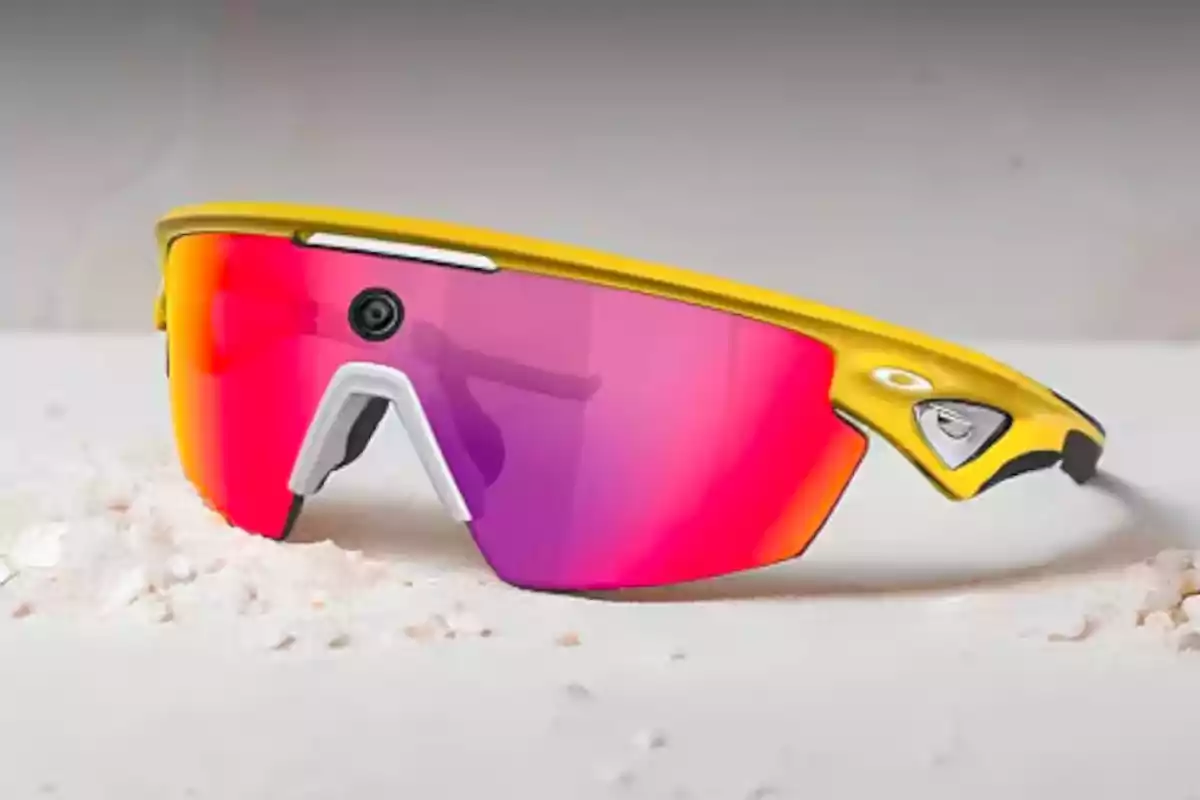 Gafas deportivas amarillas con lentes espejados rosas y una pequeña cámara en el centro Gafas deportivas amarillas con lentes espejados rosas y una pequeña cámara en el centro