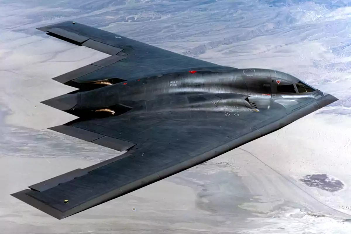 B-2 Spirit stealth bomber flying over a desert landscape B-2 Spirit stealth bomber flying over a desert landscape